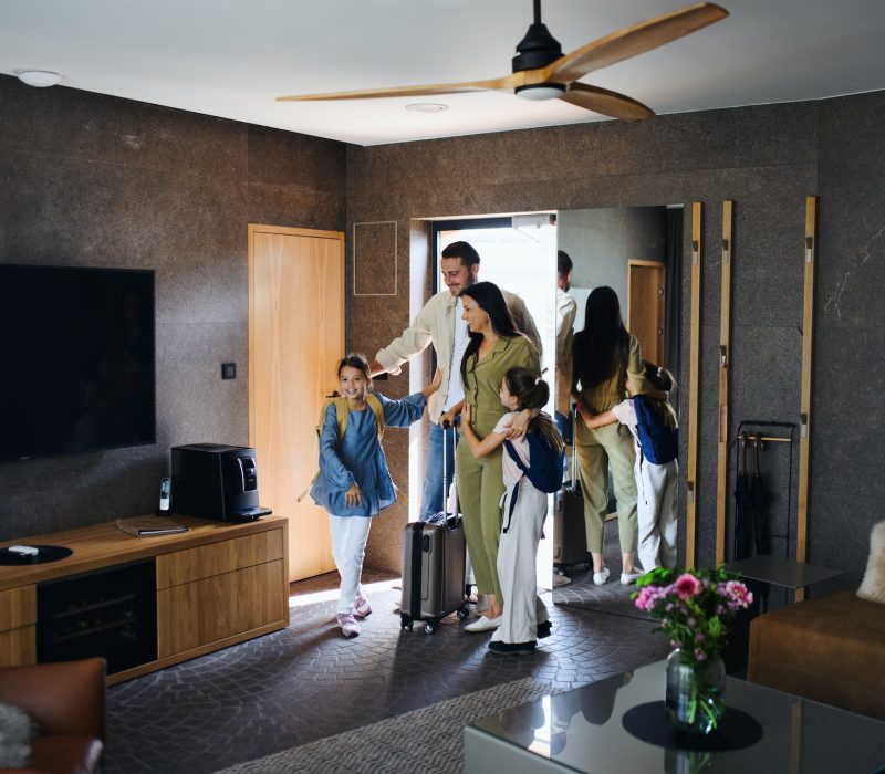 happy-young-family-with-two-children-enetring-room-at-luxury-hotel-summer-holiday.jpg